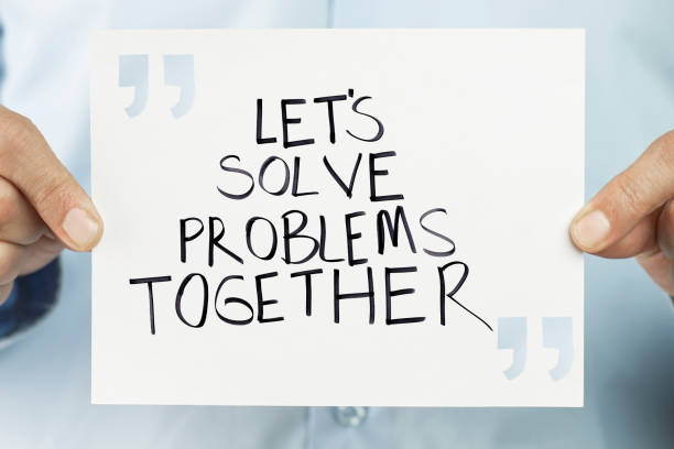 Persoon die een bord vasthoudt met de handgeschreven boodschap 'Let's Solve Problems Together', als symbool voor samenwerking, verbinding en ondersteuning van volwassenen.