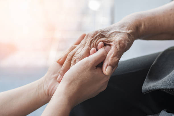 Oudere persoon met Parkinson, Alzheimer of artritis die ondersteuning ontvangt, als symbool voor zorg, ouder worden en omgaan met verlies en verandering.