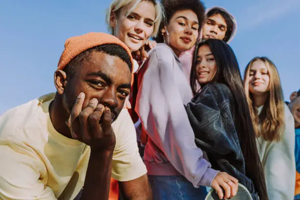 Diverse groep jongeren die samen poseert en in de camera kijkt als symbool voor verbinding, vertrouwen en jongeren therapie.