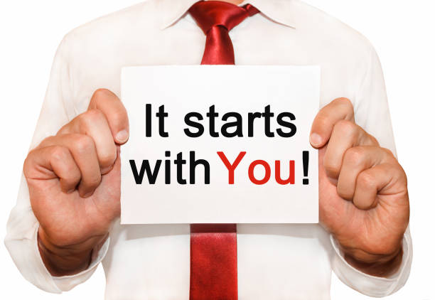 Man die een kaart vasthoudt met de tekst 'It starts with you', als symbool voor persoonlijke groei, omgaan met stress en angst.