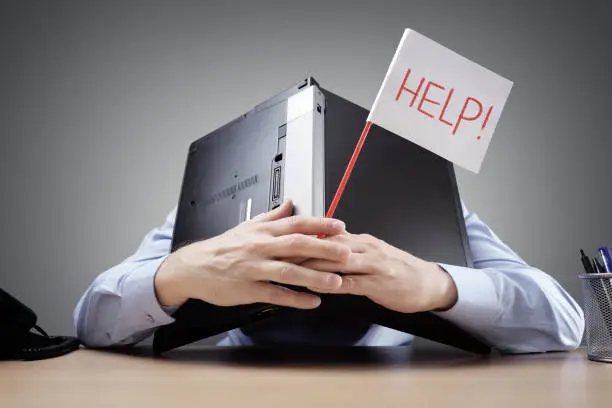 Man die het even niet meer ziet zitten. Hij steekt zijn hoofd weg in zijn laptop en hou een vlagje met "HELP" vast. Het staat symbool voor de bedrijven die in chaos zitten.